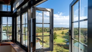 A room with large windows offering a view of a golf course. - Wellness Forest NASU (Nasu)