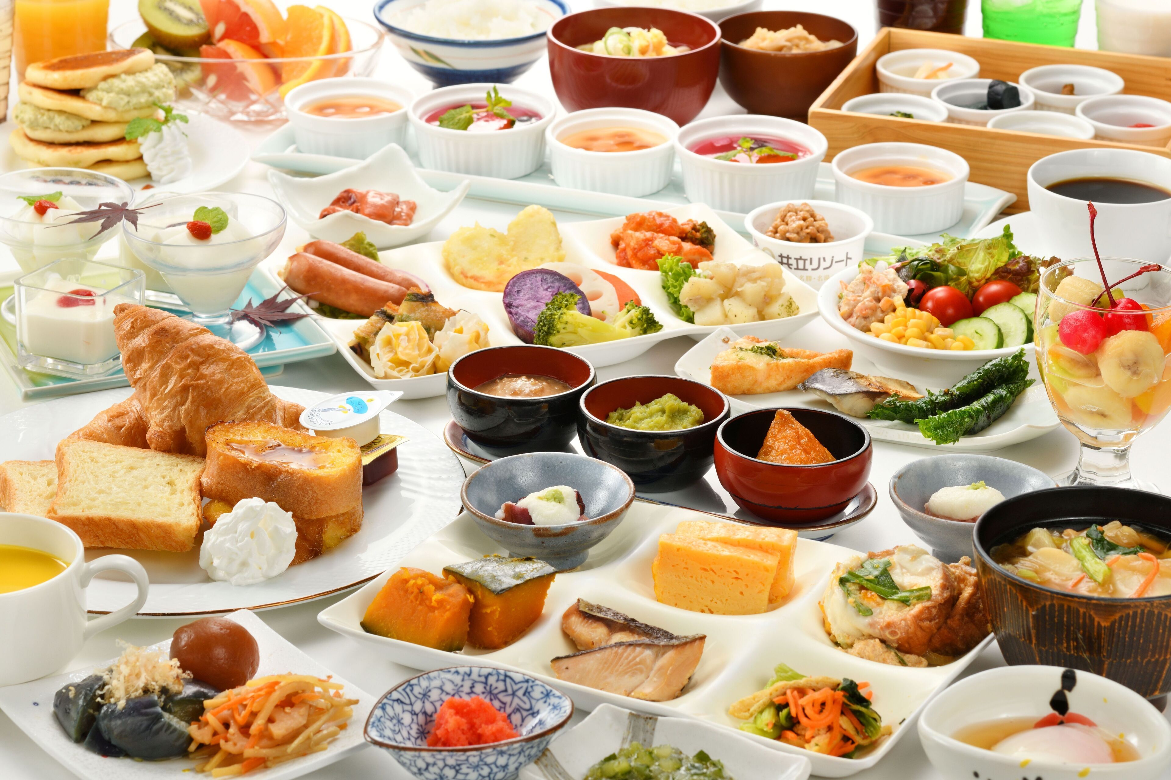 A variety of dishes and beverages on a table, including bread, soup, and salad.