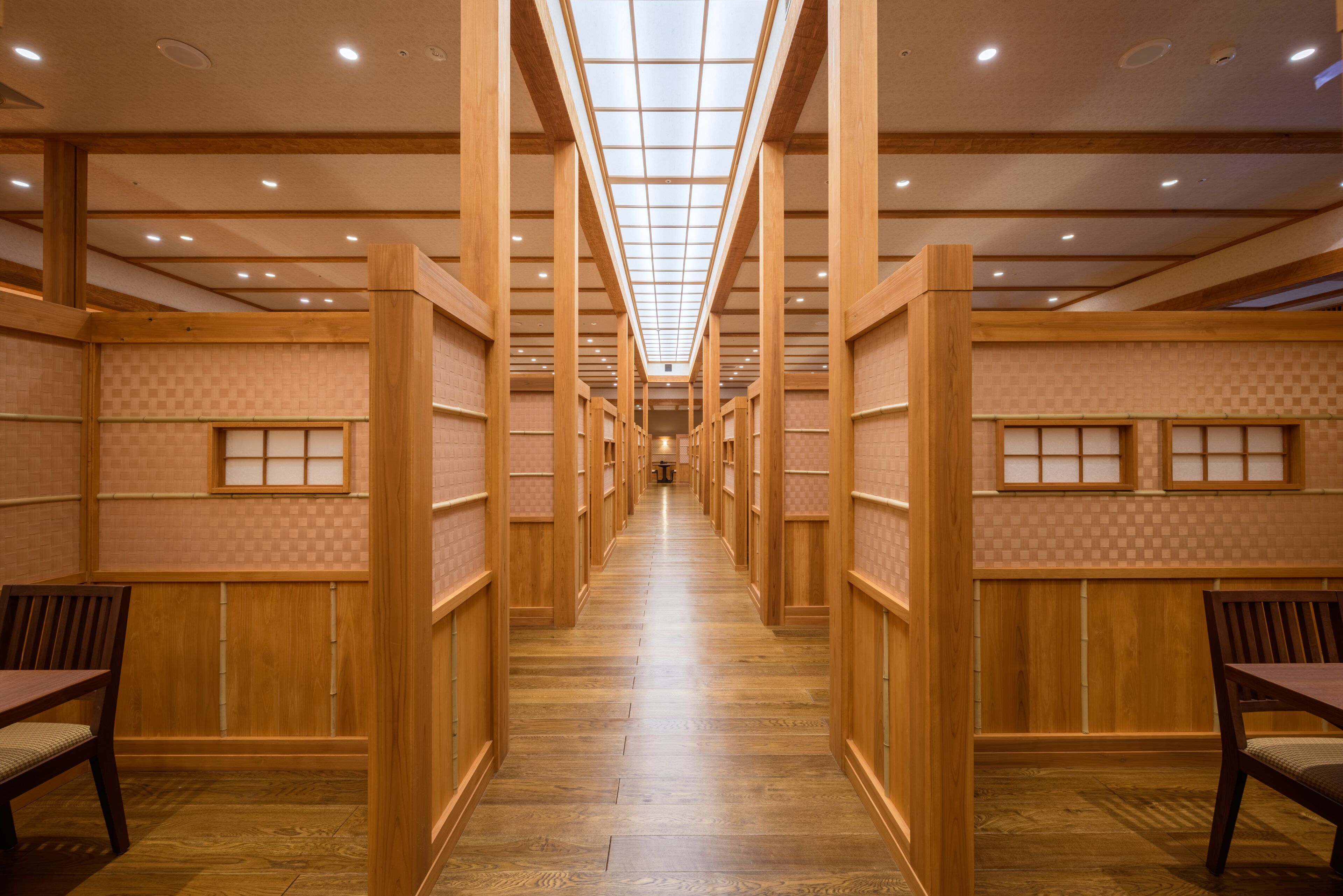 A corridor with wooden paneling and a checkered wall pattern, leading to a central area with a ceiling light fixture.