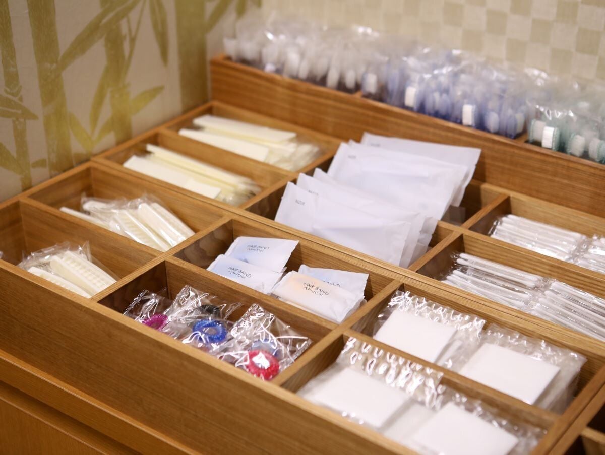 Een houten opbergunit met vakken voor diverse toiletartikelen en persoonlijke verzorgingsproducten.