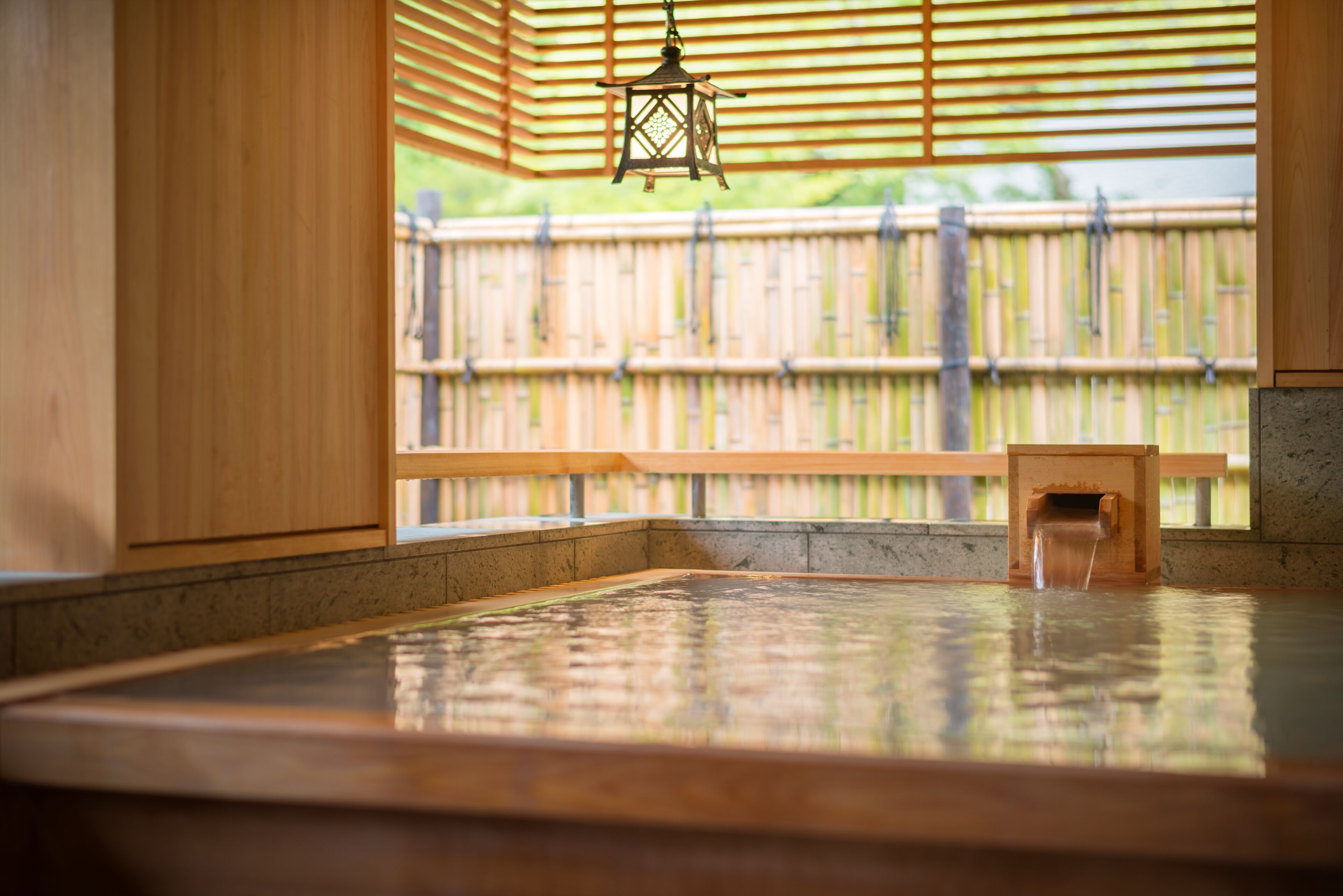 A traditional Japanese onsen with a wooden bench and a lantern.