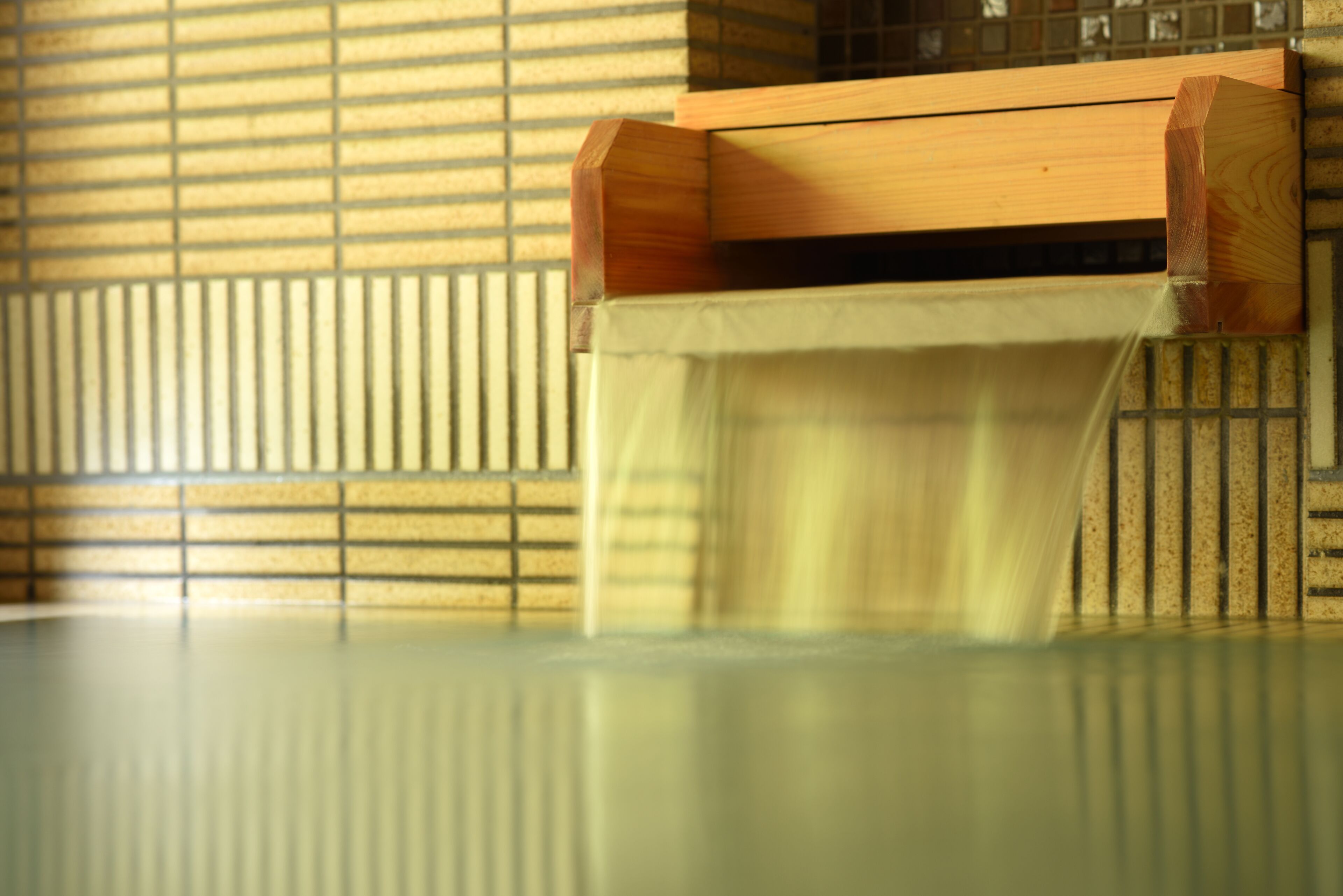 A wooden bench with a slatted backrest and a table in front.