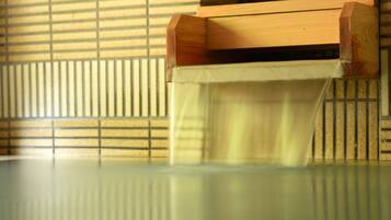 A wooden bench with a slatted backrest and a table in front.