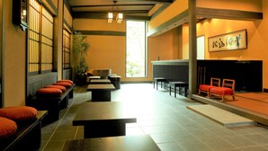 A traditional Japanese-style room with tatami flooring, low tables, and benches. - Oyado Konoha (Kusatsu)