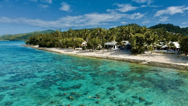 A beachside resort with clear turquoise waters, palm trees, and beach houses. - All inclusive Beachfront Villa in Fiji! (Sigatoka)
