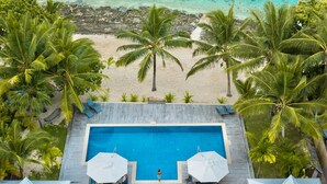 An aerial view of a resort with a swimming pool, beach, and palm trees. - All inclusive Beachfront Villa in Fiji! (Sigatoka)