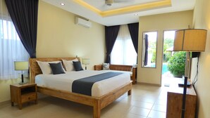 A well-lit bedroom with a large bed, bedside tables, a desk, and a view of the outdoors. - Villa Mels (Jimbaran)