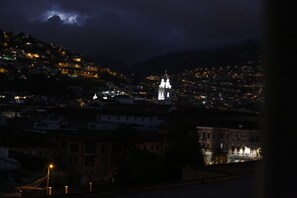 A nighttime cityscape with illuminated buildings and a prominent tower. - Casa de las Culturas San Marcos (Quito)
