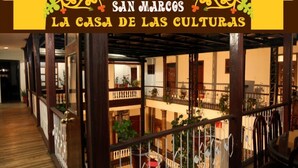 A multi-level interior with wooden floors and railings, featuring balconies with potted plants. - Casa de las Culturas San Marcos (Quito)