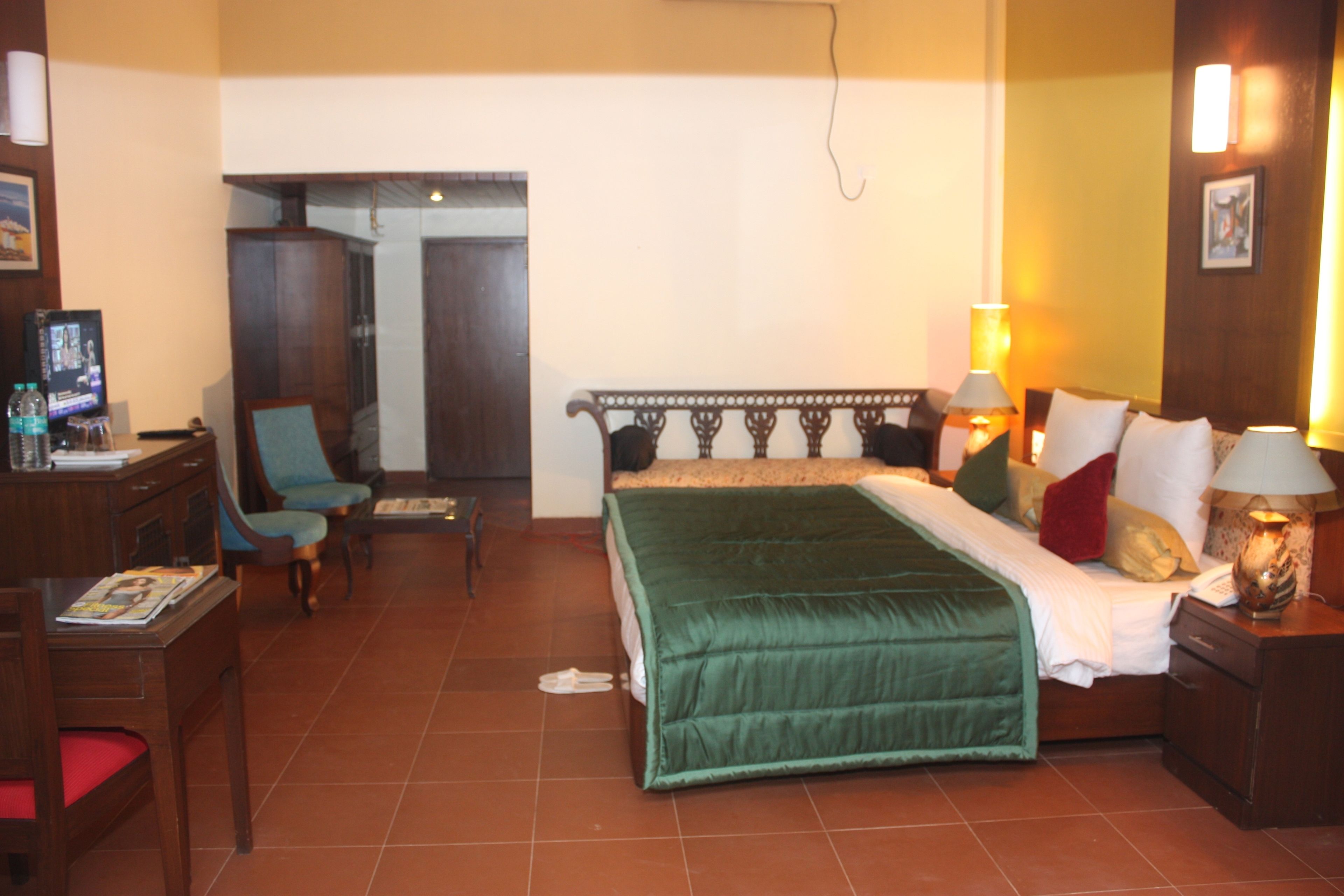 Une chambre d’hôtel équipée d’un lit, d’un bureau, d’une chaise et d’un téléviseur.