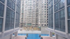 A high-rise building with a swimming pool and outdoor seating area. - Uptown BGC near St. Luke's (Taguig)
