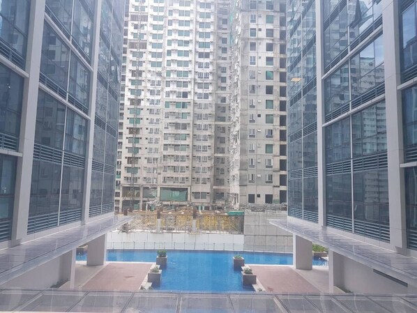 A high-rise building with a swimming pool and outdoor seating area.