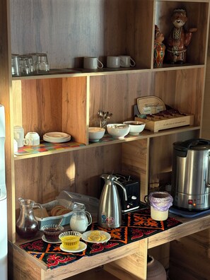 A kitchen with wooden shelves, a coffee maker, a kettle, and a Teatone tea box. - Asia Mountains (Bishkek)