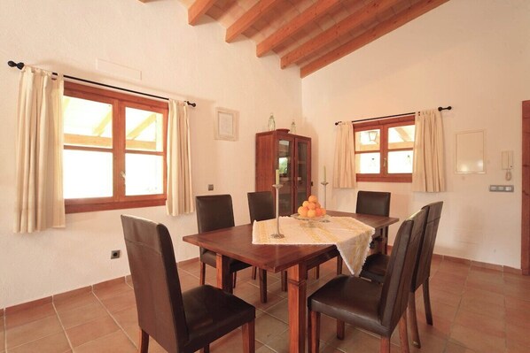 A dining area with a wooden table, six chairs, and a cabinet. - Elegant Villa - only 1.5km to Pollensa town! (Pollensa)