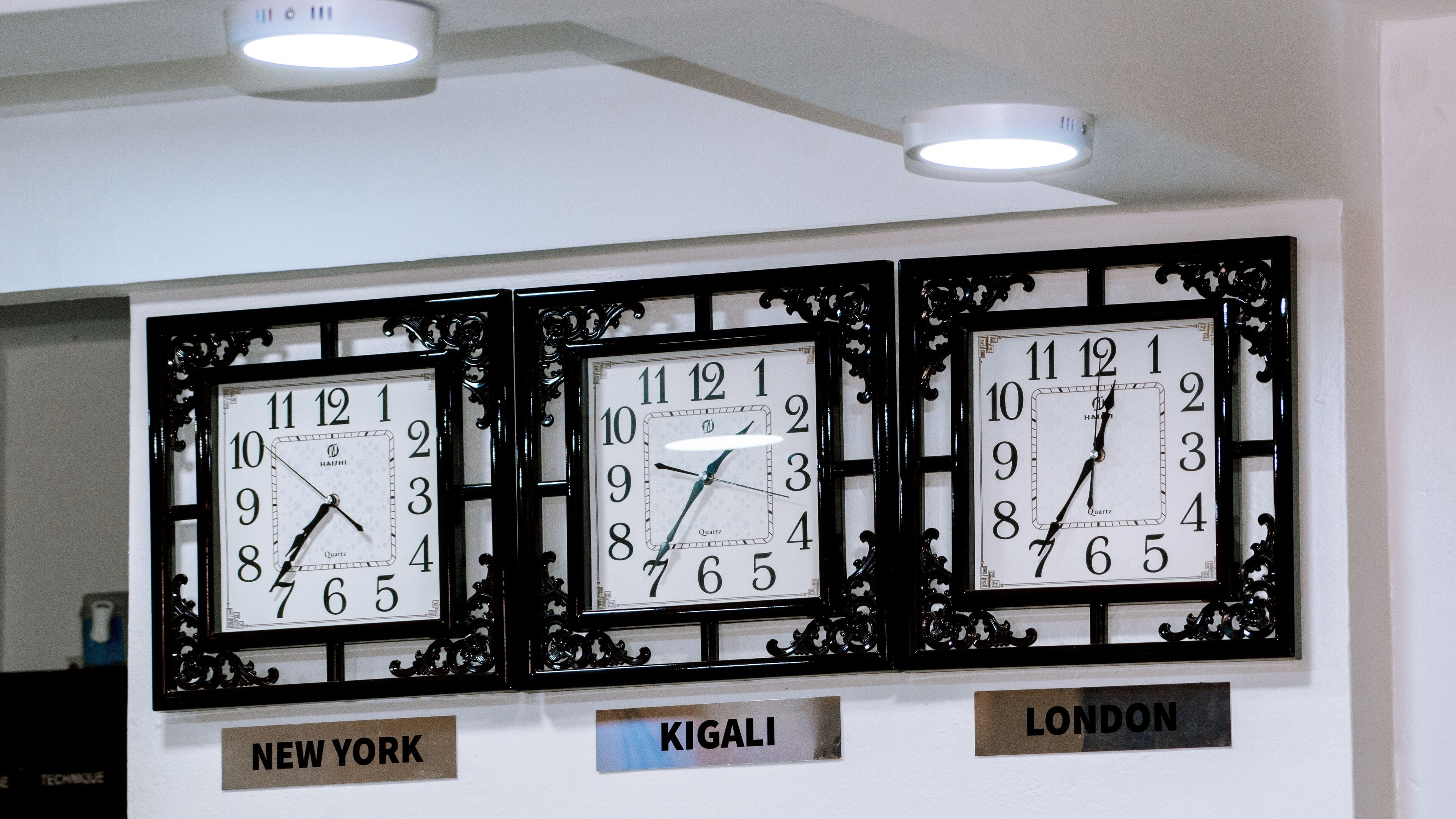 Three wall clocks labeled with city names: New York, Kigali, and London.