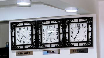 Three wall clocks labeled with city names: New York, Kigali, and London.