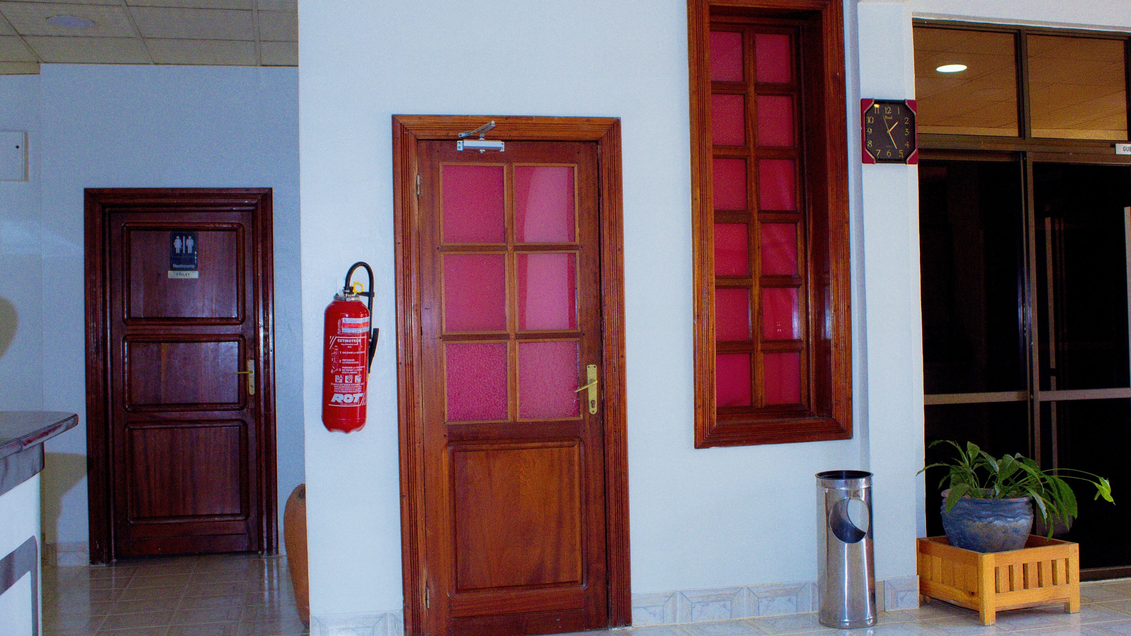 Una puerta de madera con un extintor de incendios colgado en la pared a su lado.
