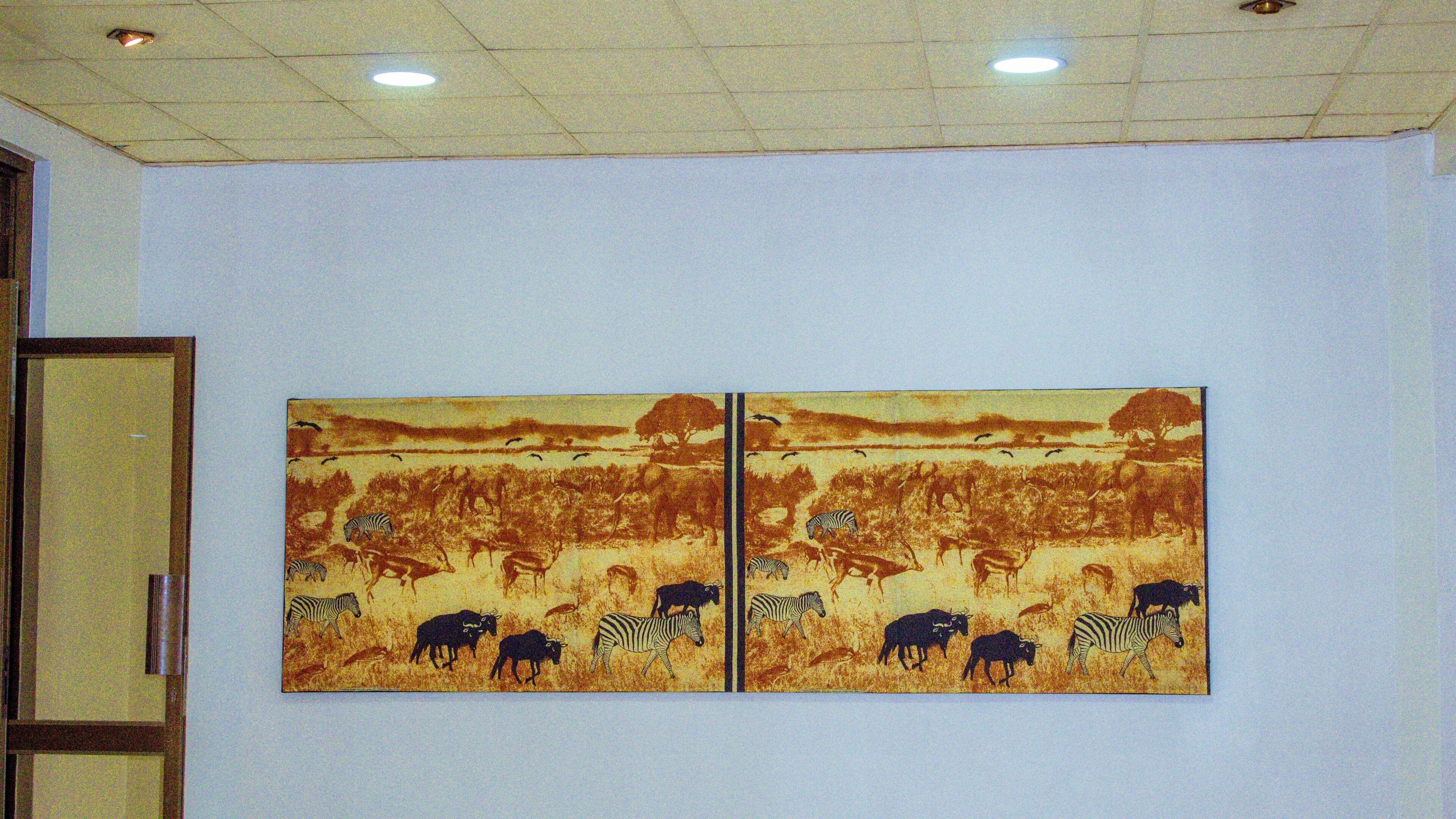 Two wildlife-themed paintings on a plain wall.