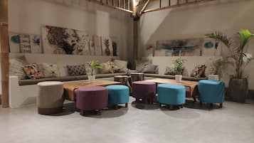 Uma sala de estar moderna com sofá, pufes e mesa de centro.