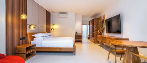 A modern bedroom with a wooden bed, a TV, and a dining area.
