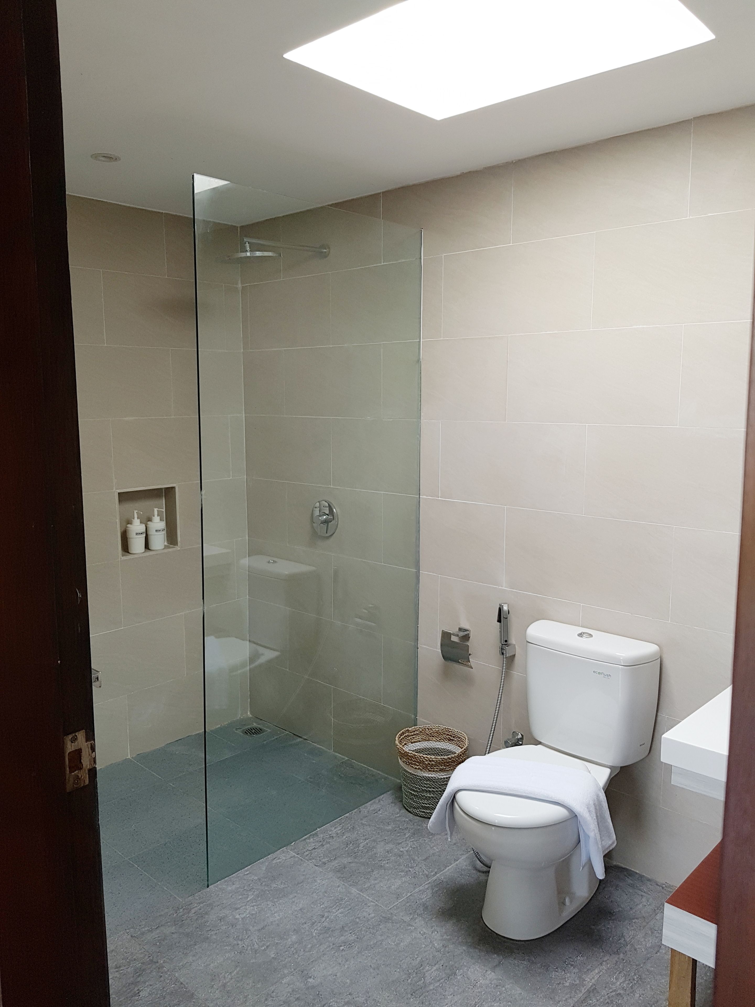 Een moderne badkamer met een douchecabine, een toilet en een wastafel.