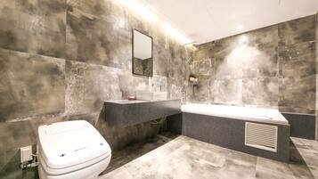Un baño moderno con inodoro, lavabo y bañera.