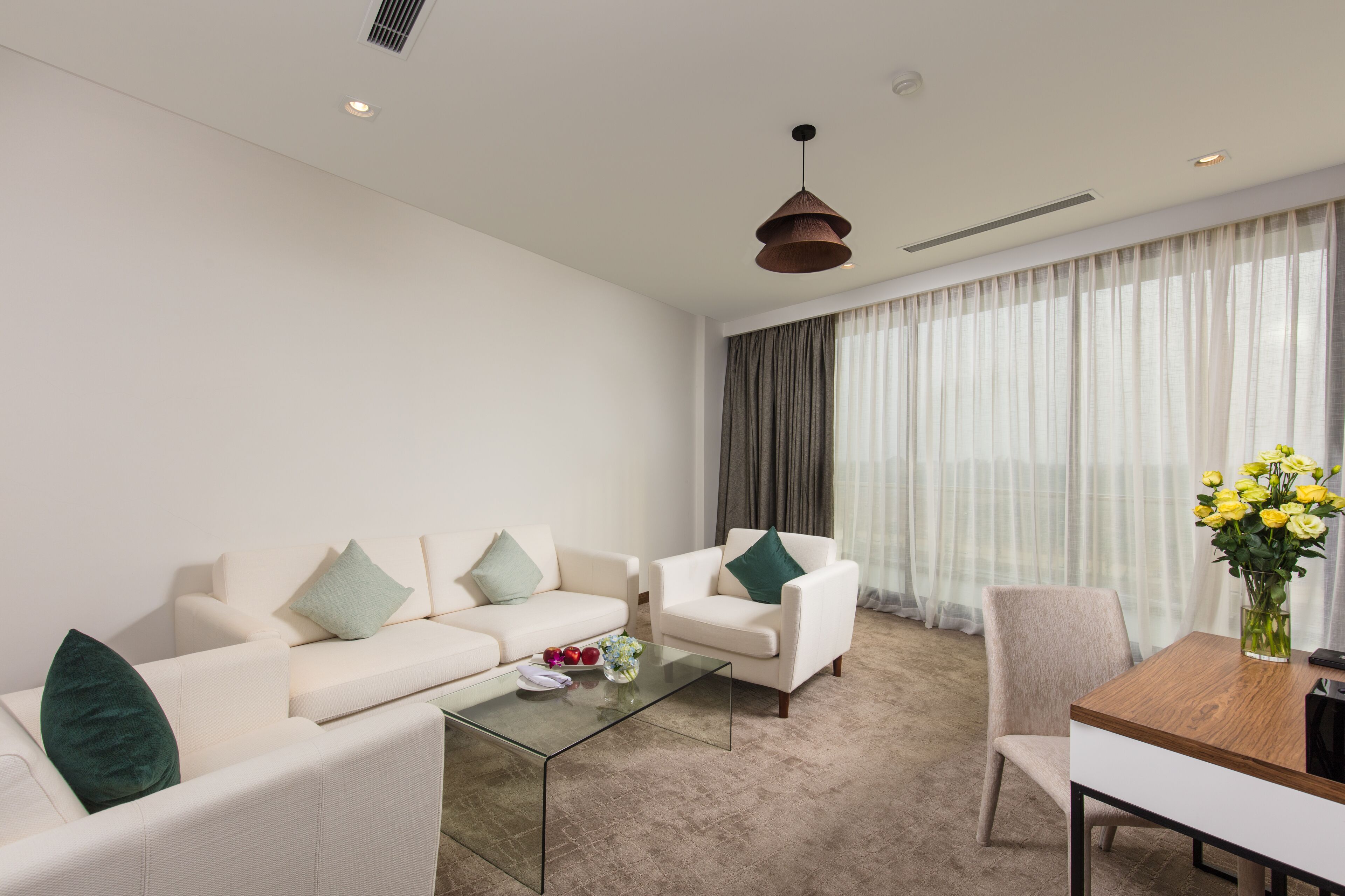 A modern living room with a sofa set, a coffee table, and a dining table.