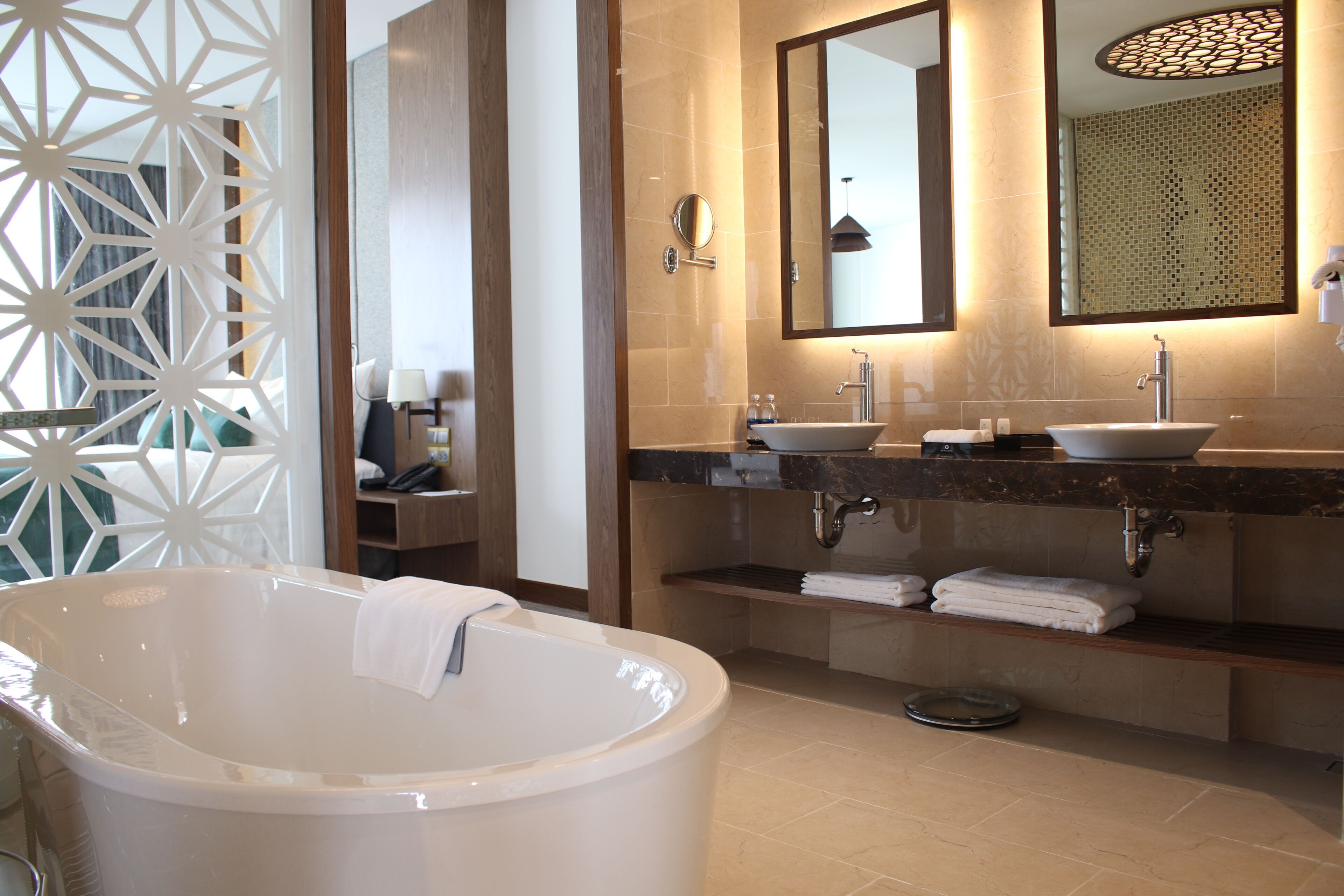 A modern bathroom with a freestanding bathtub, dual sinks, and a large mirror.