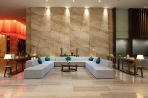 Un salon moderne avec un canapé d’angle, une table basse et un mur décoratif orné de lignes verticales.