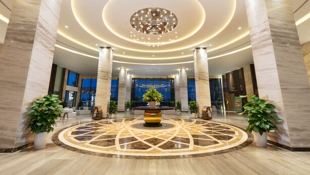 A spacious lobby with a central fountain, marble flooring, and modern lighting. - DIC Star Hotels & Resorts Vinh Phuc (Vinh Yen)