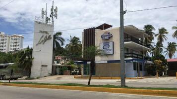 Un hotel con un cartel de cerveza Corona Extra y un cartel de ostras.