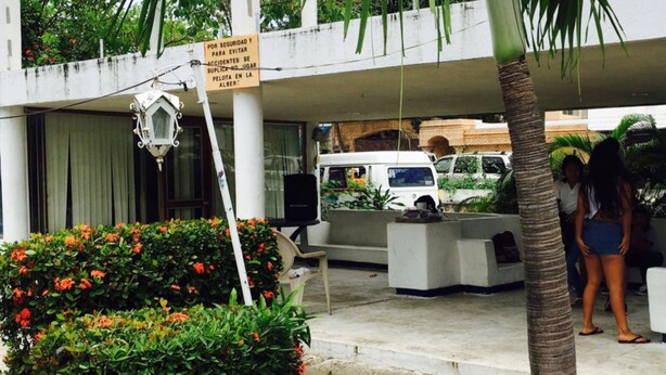 A building with a covered entrance, a sign warning against parking, and a white van parked outside. - Hotel La Jolla (Acapulco)