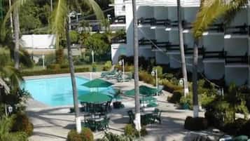 Una piscina al aire libre, camas de piscina gratis, sombrillas