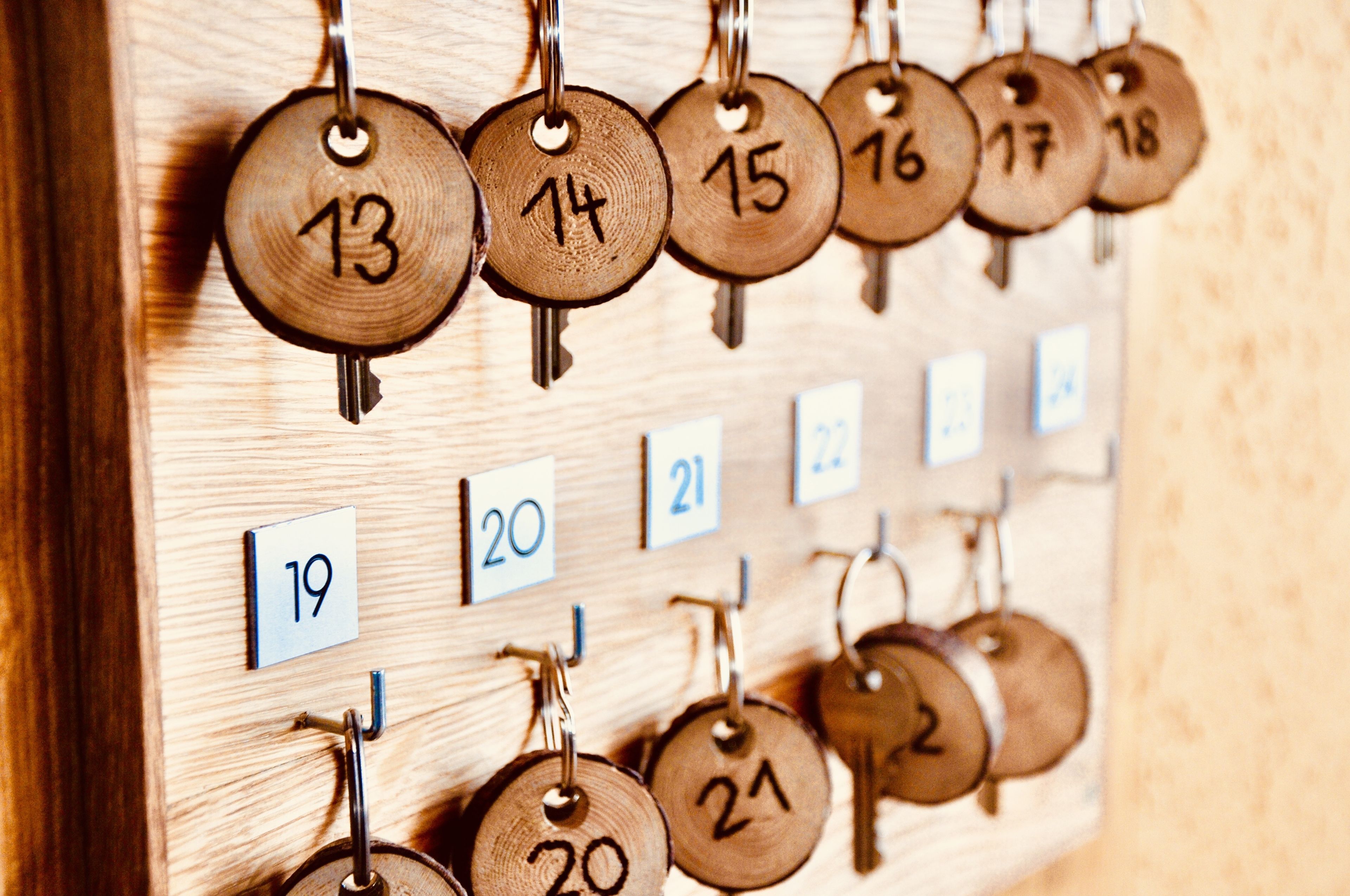 Calendario portachiavi in legno con chiavi numerate e numeri di stanza corrispondenti.