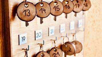 Calendario portachiavi in legno con chiavi numerate e numeri di stanza corrispondenti.