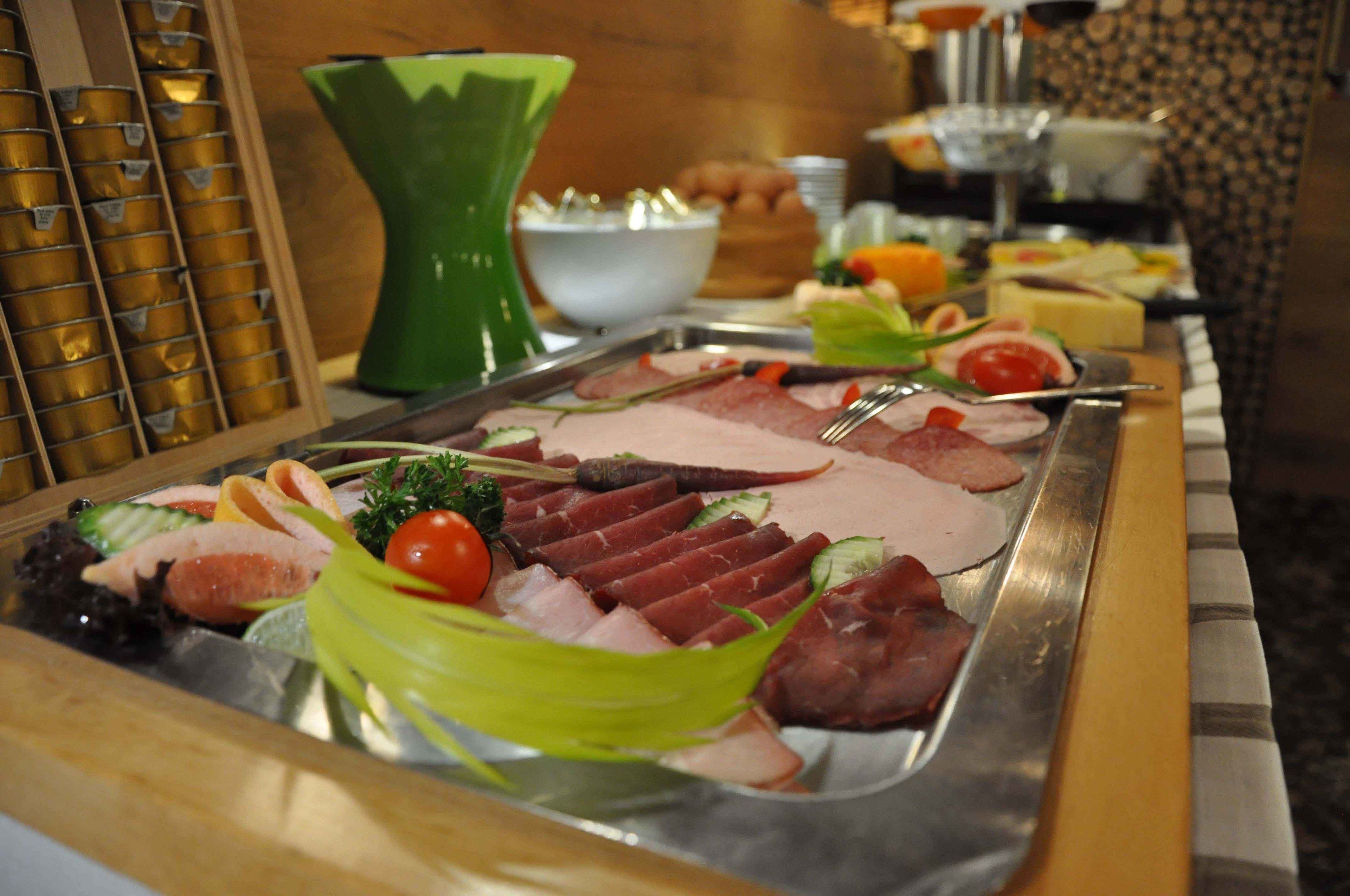 Un buffet con diverse carni e verdure.
