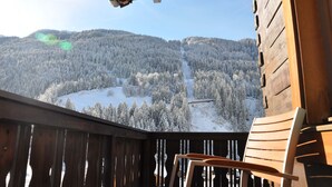 Une cabane en bois dotée d’un balcon donnant sur une montagne enneigée.