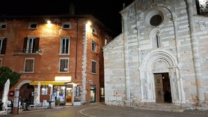 A historic building with a stone facade and a large arched entrance. - Albergo Meuble' Olivi (Toscolano Maderno)