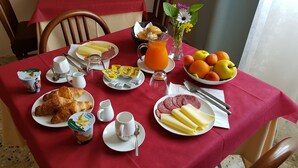 A breakfast table set with croissants, cheese, ham, fruit, and juice. - Albergo Meuble' Olivi (Toscolano Maderno)