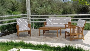 A patio with a white fence, wooden furniture, and lush greenery. - Villa Marian (Apokoronas)