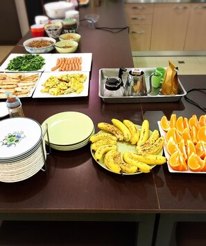 Una mesa de buffet con diversos alimentos y utensilios de servir.