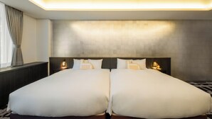 Un lit double avec une tête de lit, des tables de chevet et un luminaire fixé au mur.