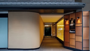 Un couloir d’hôtel moderne, avec un mur incurvé à gauche et un mur recouvert de panneaux en bois à droite.