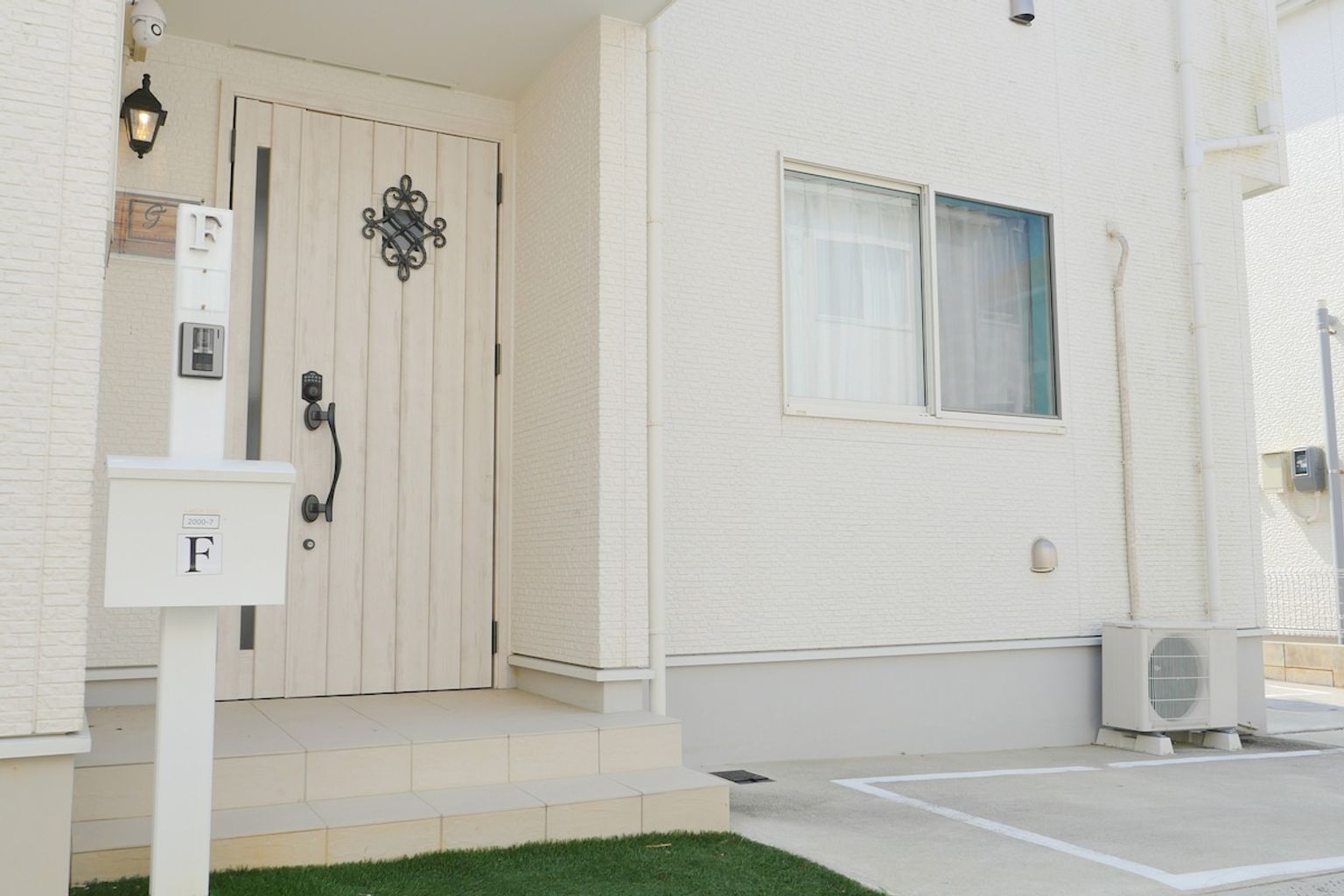 A building entrance with a white door, a mailbox, and a small window.