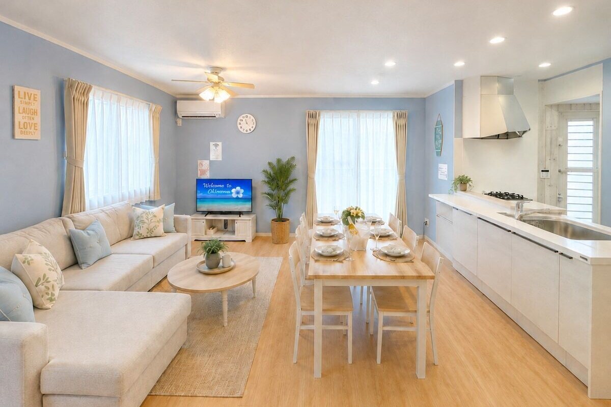 A modern living room with a sofa, coffee table, and dining area set for four.