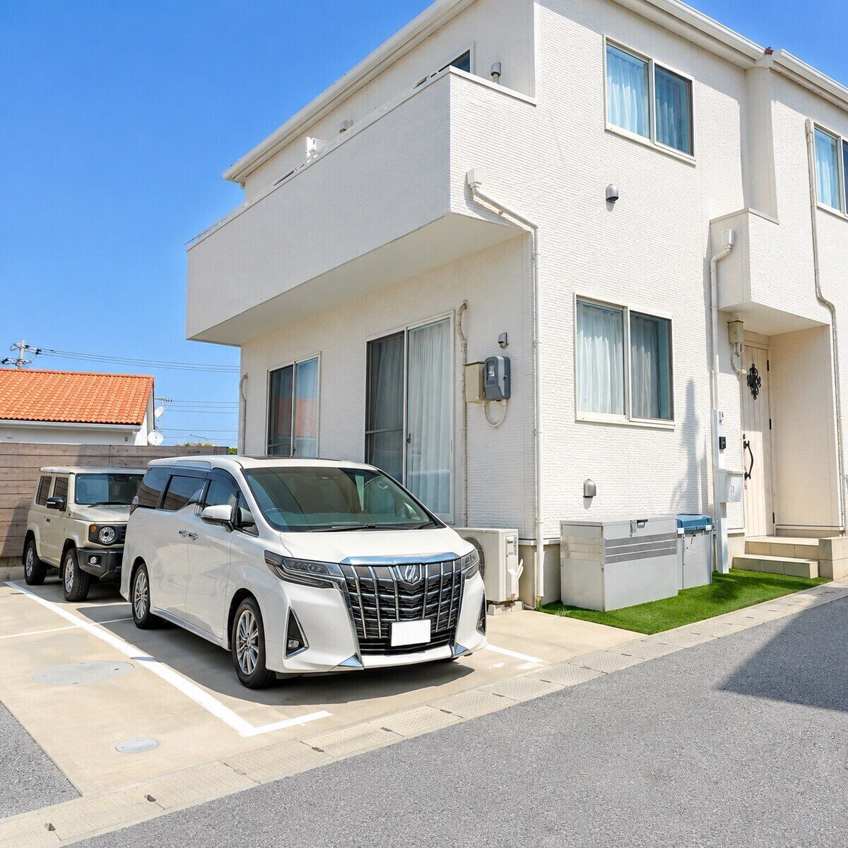 A two-story white building with a parking area.