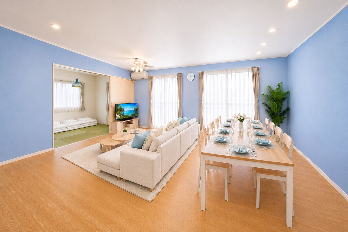 Una sala moderna con un sofá, una mesa de comedor para seis personas y una televisión.