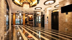 A spacious lobby with a polished marble floor, multiple chandeliers, and a modern elevator. - APA Hotel Osaka Umeda (Osaka)
