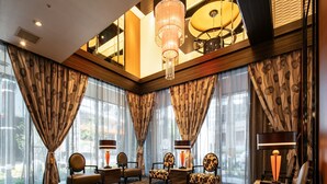 A spacious lobby with a checkered floor, large windows with patterned curtains, and a chandelier. - APA Hotel Osaka Umeda (Osaka)