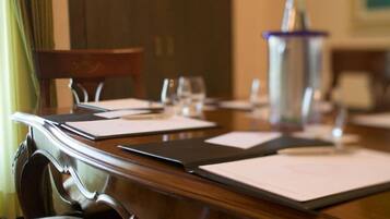 A conference table with documents, a water bottle, and glasses.